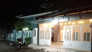 A building with a covered entrance, a gated area, and a parked motorcycle. - 999 KHS 2 Homestay (Banyuwangi)