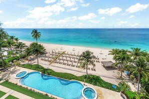 A resort with a swimming pool, beach, and ocean view. - Beachcomber 34 by Grand Cayman Villas (7 Mile Beach)