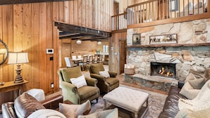 A cozy living room with a stone fireplace, wooden walls, and comfortable seating. - 5 BEDROOM, MOUNTAIN VIEWS, SOUNDS OF STREAM, LARGE DECK, HOT TUB, CLASSIC SUNDANCE CABIN (Sundance)