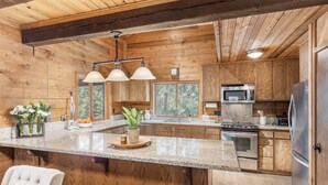 A kitchen with wooden cabinets, granite countertops, stainless steel appliances, and pendant lighting. - 5 BEDROOM, MOUNTAIN VIEWS, SOUNDS OF STREAM, LARGE DECK, HOT TUB, CLASSIC SUNDANCE CABIN (Sundance)