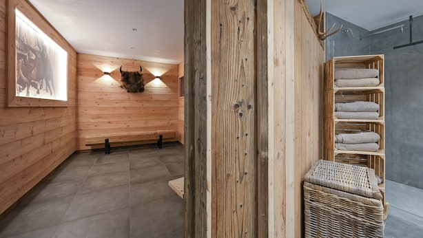 A wooden interior with a bench, a wall-mounted bull head, and a shelf with towels. - Central, south-facing terrace, mountain view, sauna, ski locker, free summer cable car (Oberstdorf)