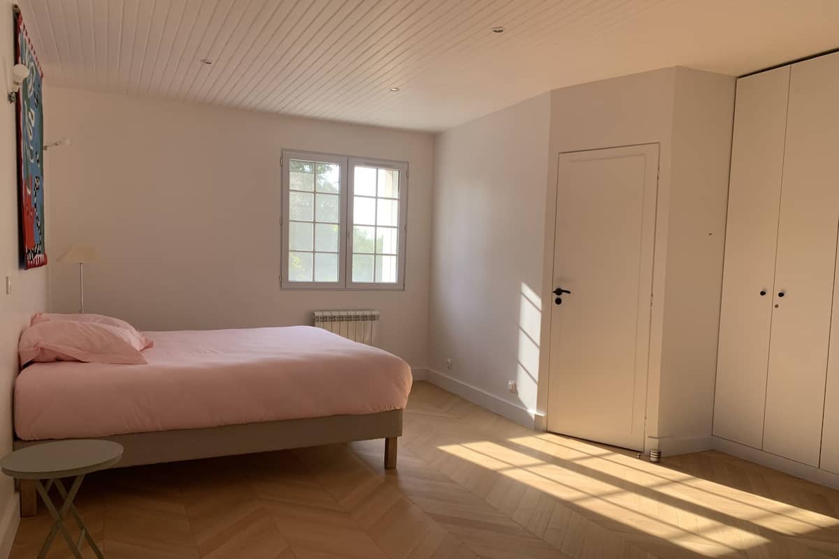 Une chambre à coucher avec un lit, un radiateur, une fenêtre et une armoire.