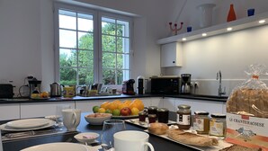 Une cuisine moderne dotée d’une grande fenêtre, d’une machine à café et de divers produits alimentaires disposés sur le plan de travail.