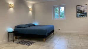 Une chambre moderne avec un lit, deux lampes fixées au mur, une fenêtre et un tableau.