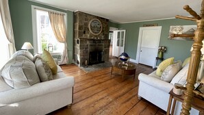 A living room with two sofas, a fireplace, and a wooden floor. - Stone Hearth Inn and Eatery (Chester)