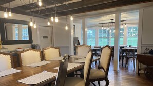 A conference room with a long wooden table, multiple chairs, and a large window providing natural light. - Stone Hearth Inn and Eatery (Chester)