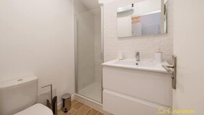 Ein modernes Badezimmer mit Toilette, Waschbecken und Dusche.