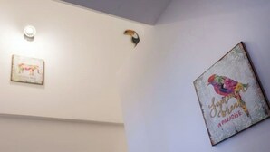 Eine Wand mit zwei gerahmten Kunstwerken und einer Leuchte.