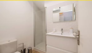 Une salle de bain moderne équipée de toilettes, d’un lavabo et d’une douche.