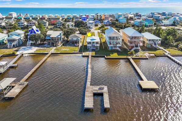 A coastal residential area with a marina, houses, and a pier.