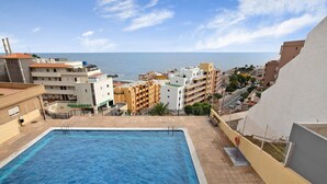Una piscina con vistas al mar y edificios.