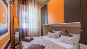 Une chambre à coucher avec un lit, des oreillers, un miroir et une armoire.