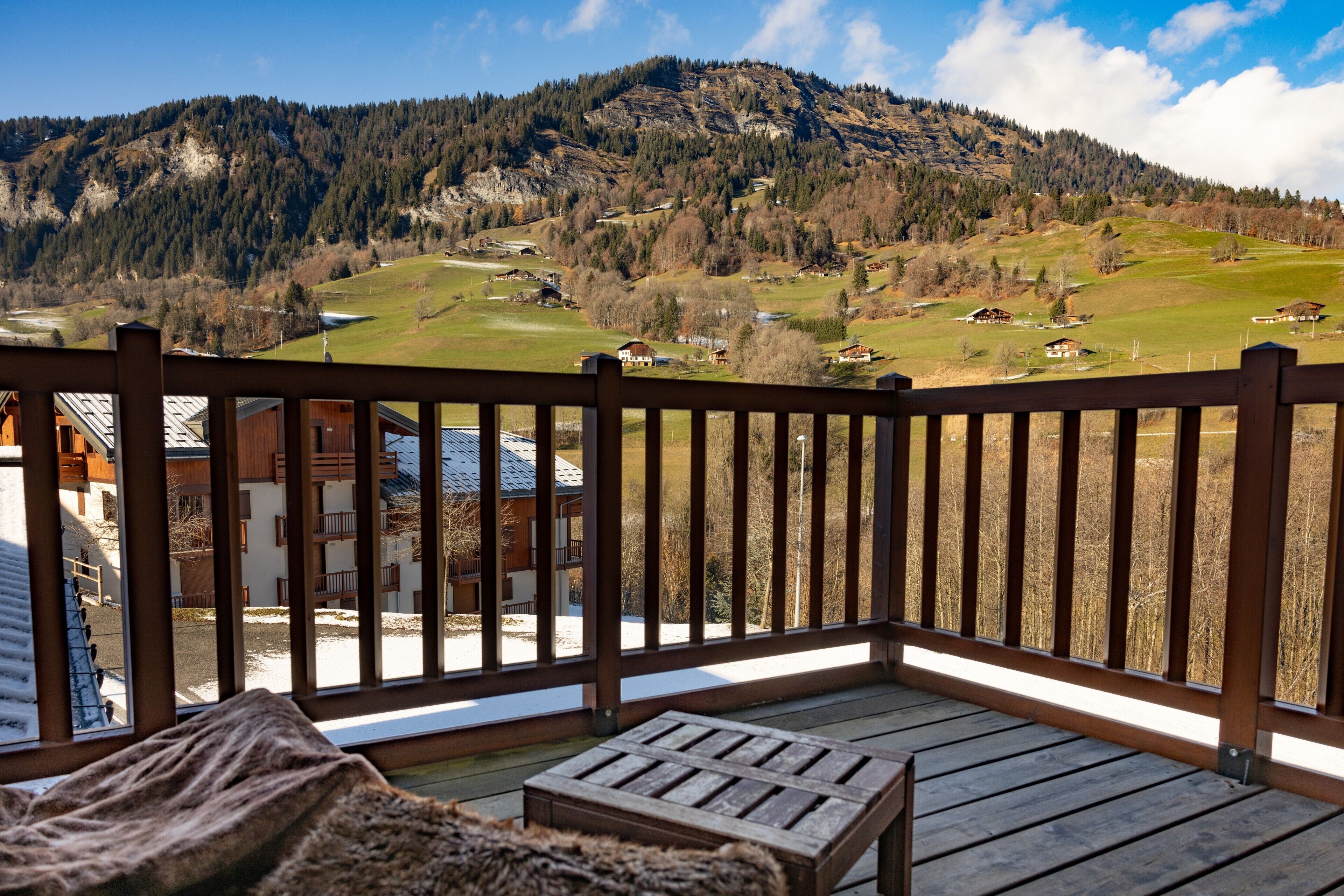 Una terraza de madera con vistas a un paisaje montañoso.