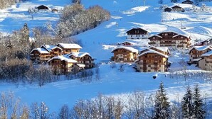 A snow-covered mountain area with wooden chalets. - '12 MN Megève Studio Comfort' with Mountain View (Flumet)