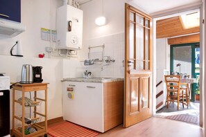 A compact kitchen with a built-in oven, a coffee machine, and a small sink.