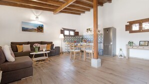 Ein Wohnzimmer mit Sofa, Couchtisch und Essbereich mit Stühlen.