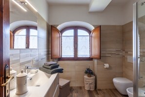 Une salle de bain moderne équipée d’un lavabo, de toilettes et d’une douche.