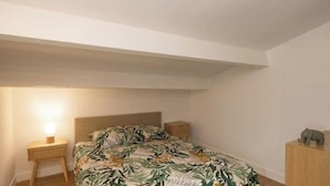 A bedroom with a bed, bedside table, nightstand, and a small wooden cabinet. - Le Morgan - Magnificent city center apartment with parking space (Salon-de-Provence)