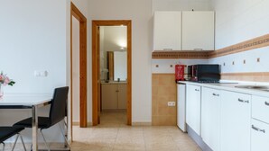A kitchen with white cabinets, a microwave, and a tiled backsplash.