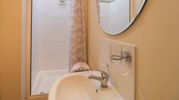 Un baño con bañera, lavabo, espejo y cortina de ducha.