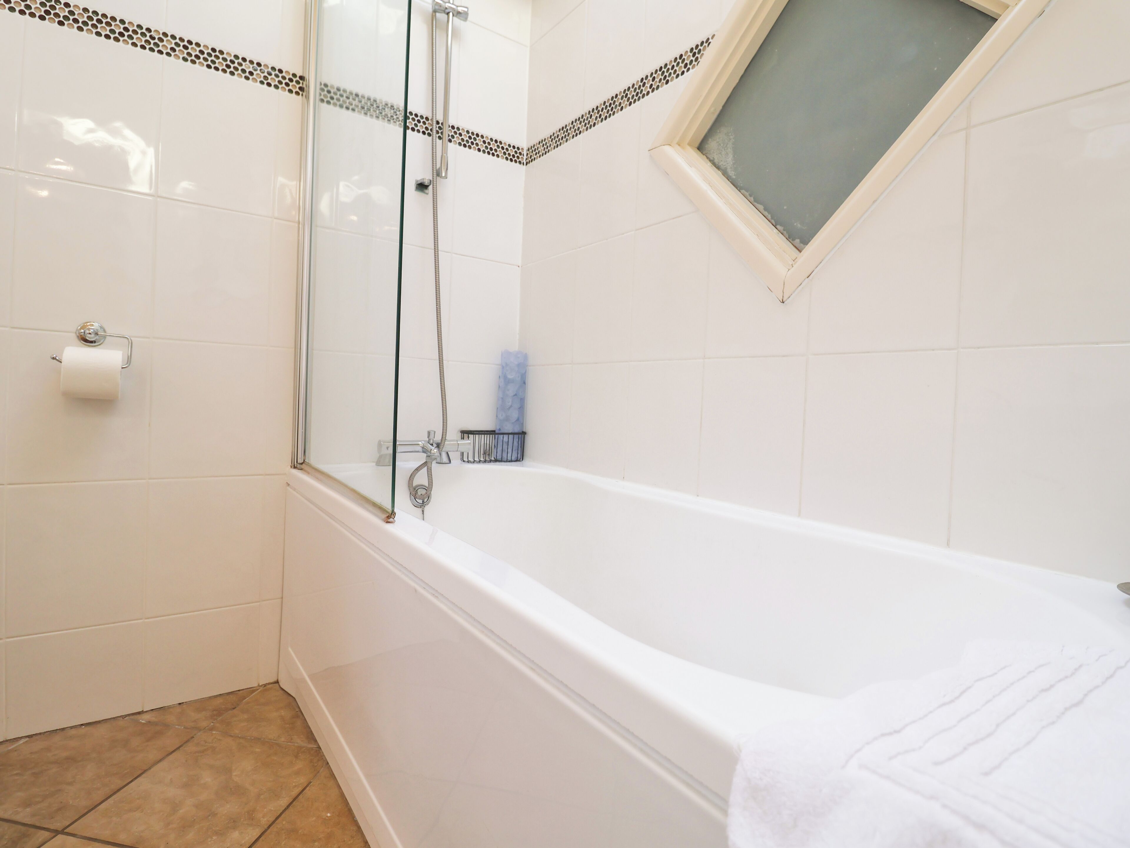 Un bagno con doccia vetrata, vasca da bagno e finestra.