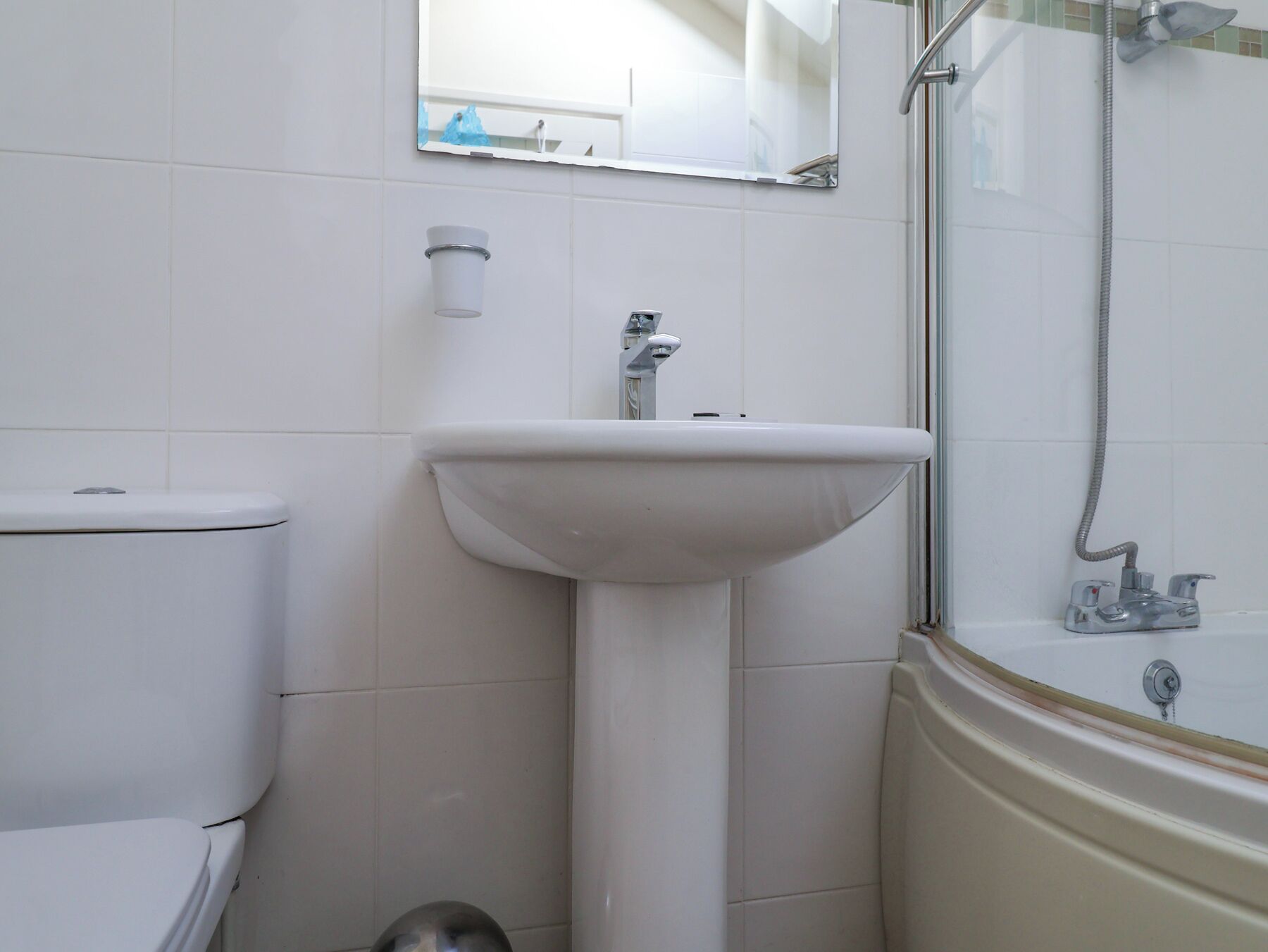 A bathroom with a toilet, sink, and shower.