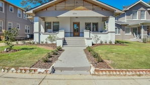 A modern two-story house with a front porch, a visible address number, and a well-maintained lawn.
