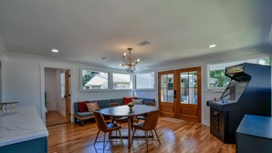 A modern kitchen with a dining area, wooden flooring, and a built-in grill station.
