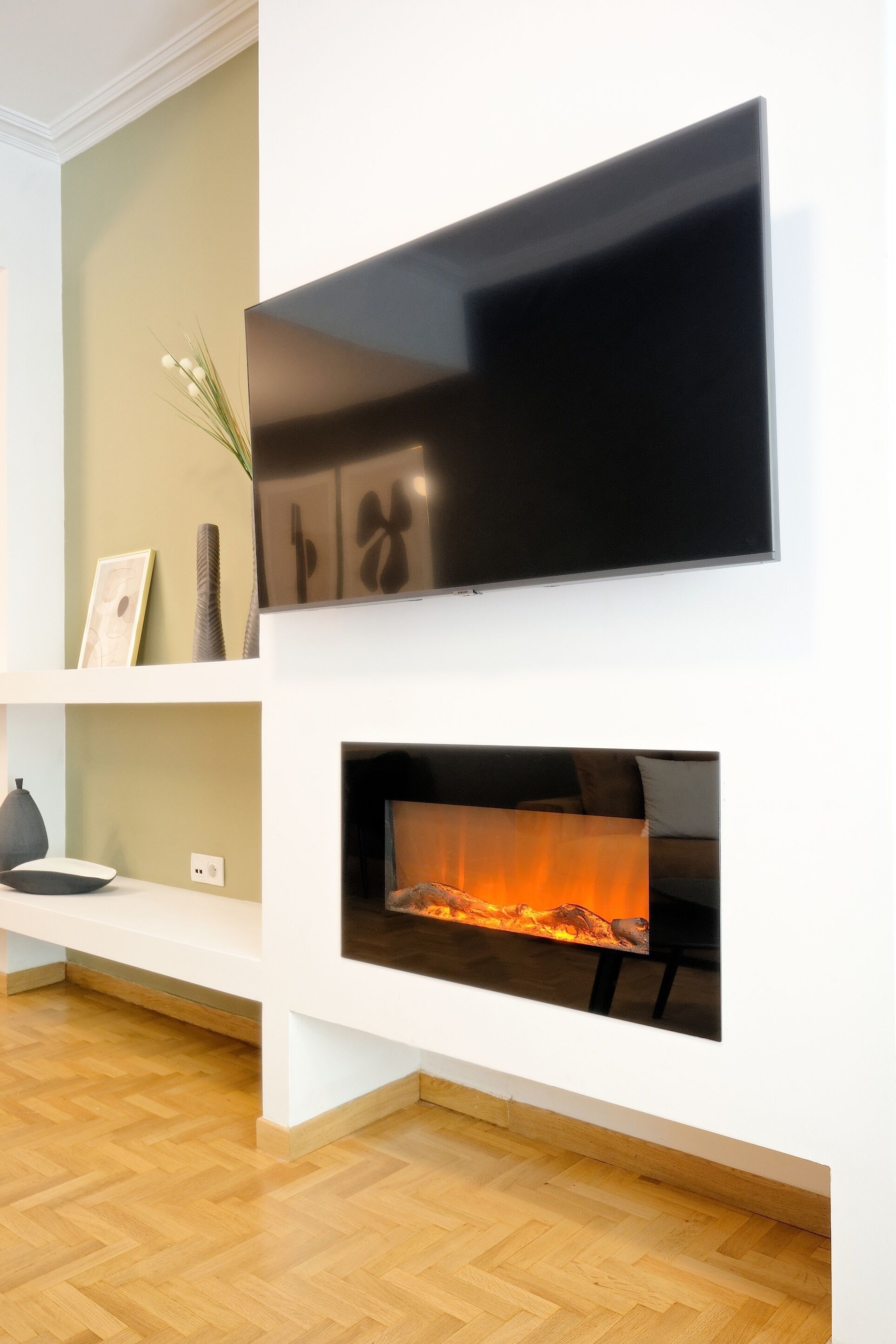 Un salon moderne avec un téléviseur à écran plat fixé au-dessus d’une cheminée.