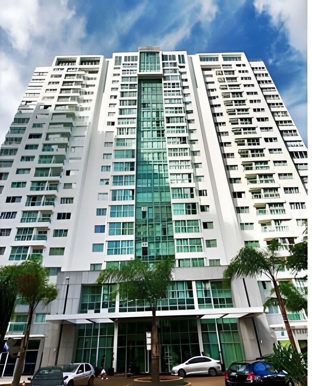 A high-rise building with multiple floors, large windows, and a central glass facade.