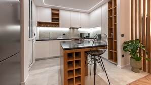 A modern kitchen with a central island, wooden cabinets, and built-in shelves. - Phaedrus Living: Luxury Penthouse Ploutarchou (Athens)