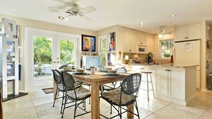 Una cocina amplia con comedor, que incluye una mesa de madera, sillas y un ventilador de techo.
