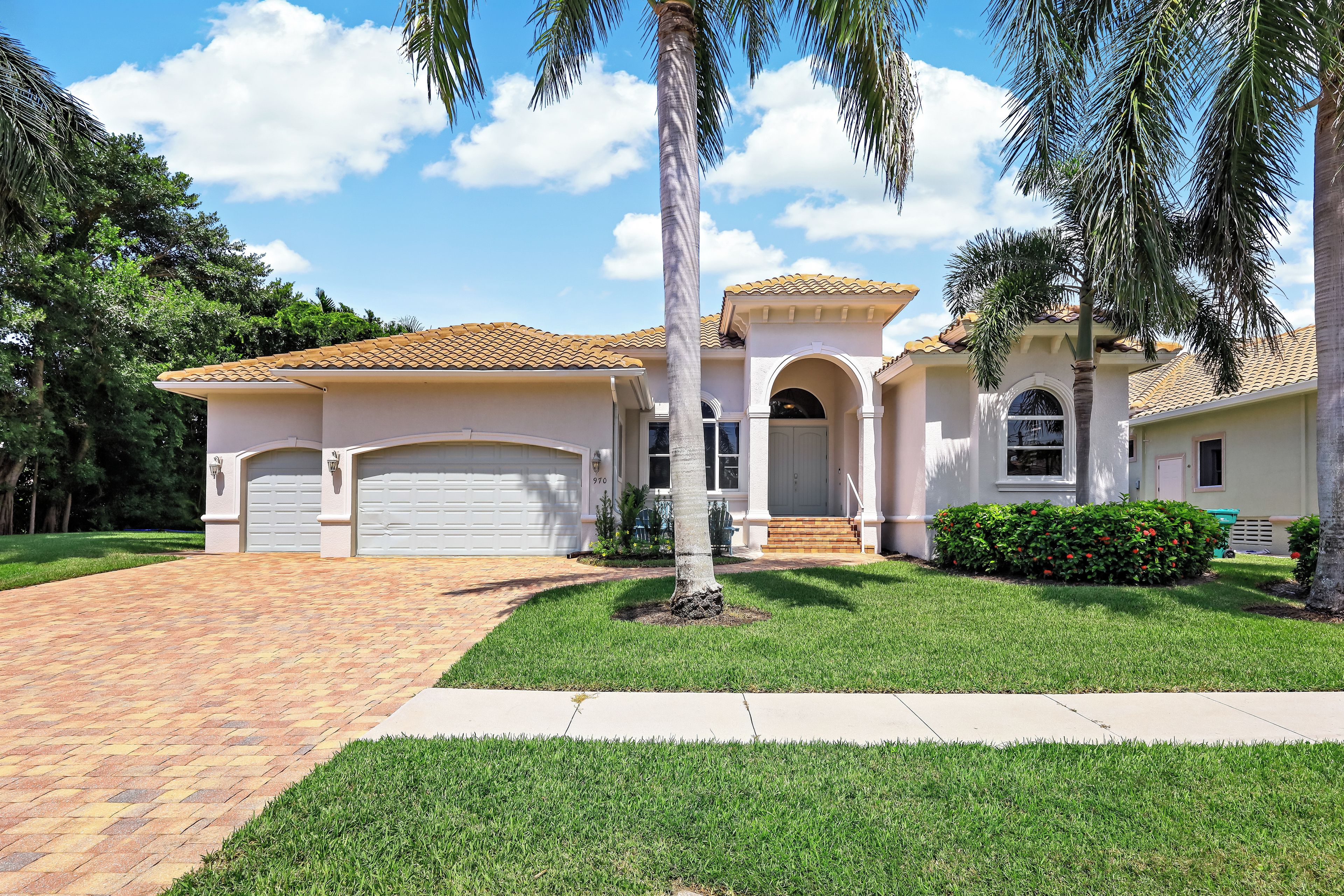 A two-story house with a tiled roof, a garage, and a well-maintained lawn.