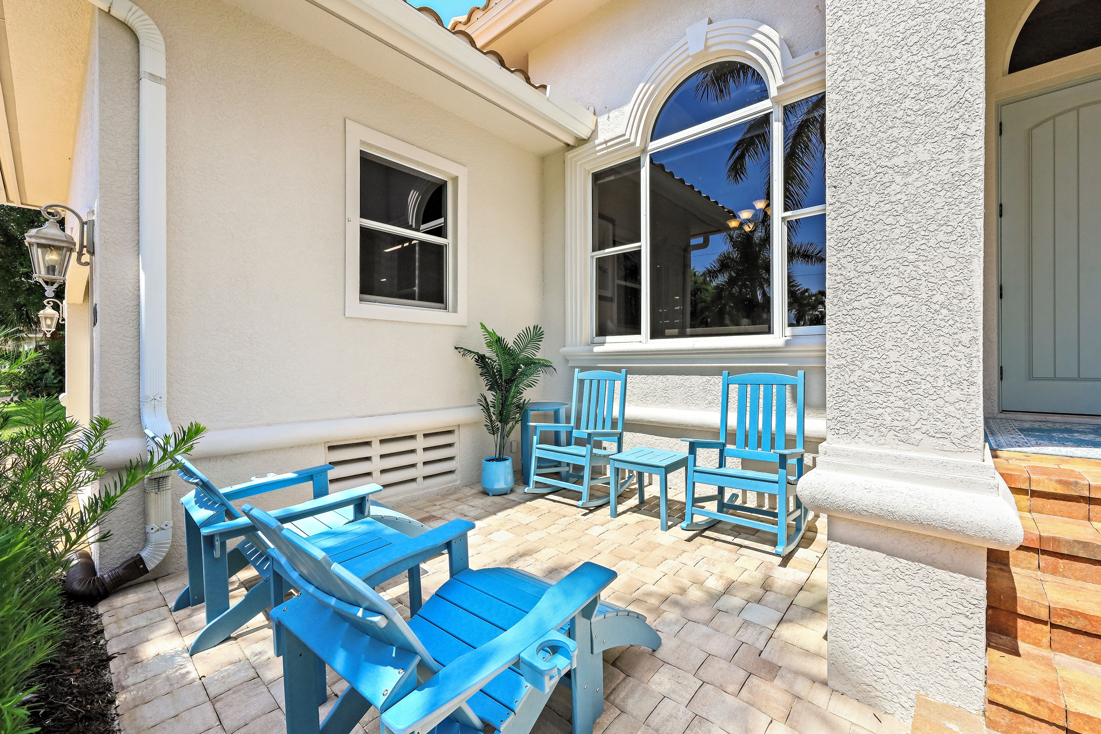 A patio with blue furniture and a potted plant.