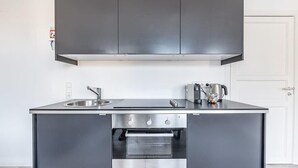 Una cuina moderna amb electrodomèstics d'acer inoxidable, un forn de sobretaula i un rentaplat.