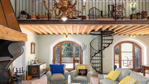 A spacious loft with a high ceiling, exposed wooden beams, a fireplace, a staircase, and large arched windows. - Romantic Villa with private pool - Il Pollaio (Volterra)