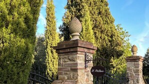 A stone gate with a sign reading "Il Polaio" and a metal fence. - Romantic Villa with private pool - Il Pollaio (Volterra)