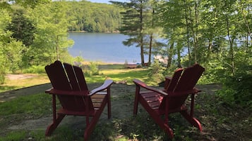 Relax in serene lakeside surroundings with a view of the calm lake and lush greenery.