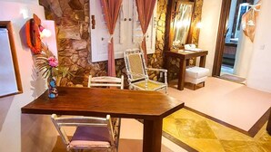 Un'area pranzo con parete in pietra, un tavolo da pranzo in legno e due sedie.