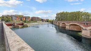 A river with a bridge and buildings in the background. - Getaway For 2, Beautiful Studio Near The Garonne (Toulouse)