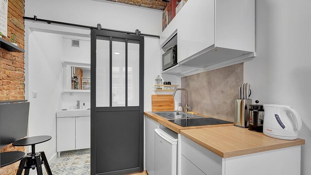A compact kitchen with a sliding door, a microwave, a toaster, and a sink. - Getaway For 2, Beautiful Studio Near The Garonne (Toulouse)