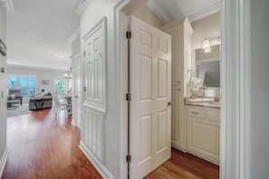 A spacious living area with hardwood flooring, a gray sofa, and a dining table.