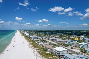 Eine Wohngegend an der Küste mit Strand, Häusern und blauem Himmel.