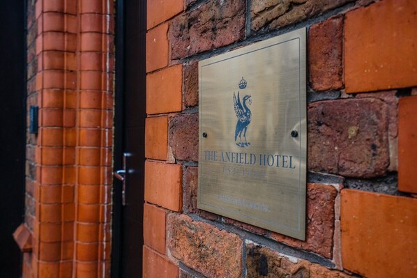 A plaque on a brick wall with the text "The Anfield Hotel" and a date "1886". - The Anfield Hotel (Liverpool)