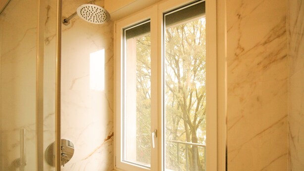 A bathroom with a shower, a window, and a view of trees outside. - Italianway Easy - Caterina da Forlì 6 (Milan)