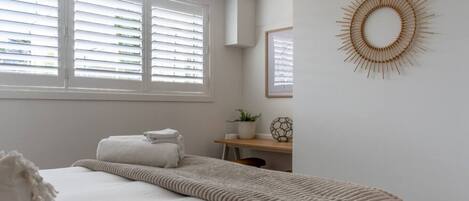 2 habitaciones, escritorio y tabla de planchar con plancha