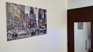 Un pasillo con un cuadro grande en blanco y negro que muestra un paisaje urbano.