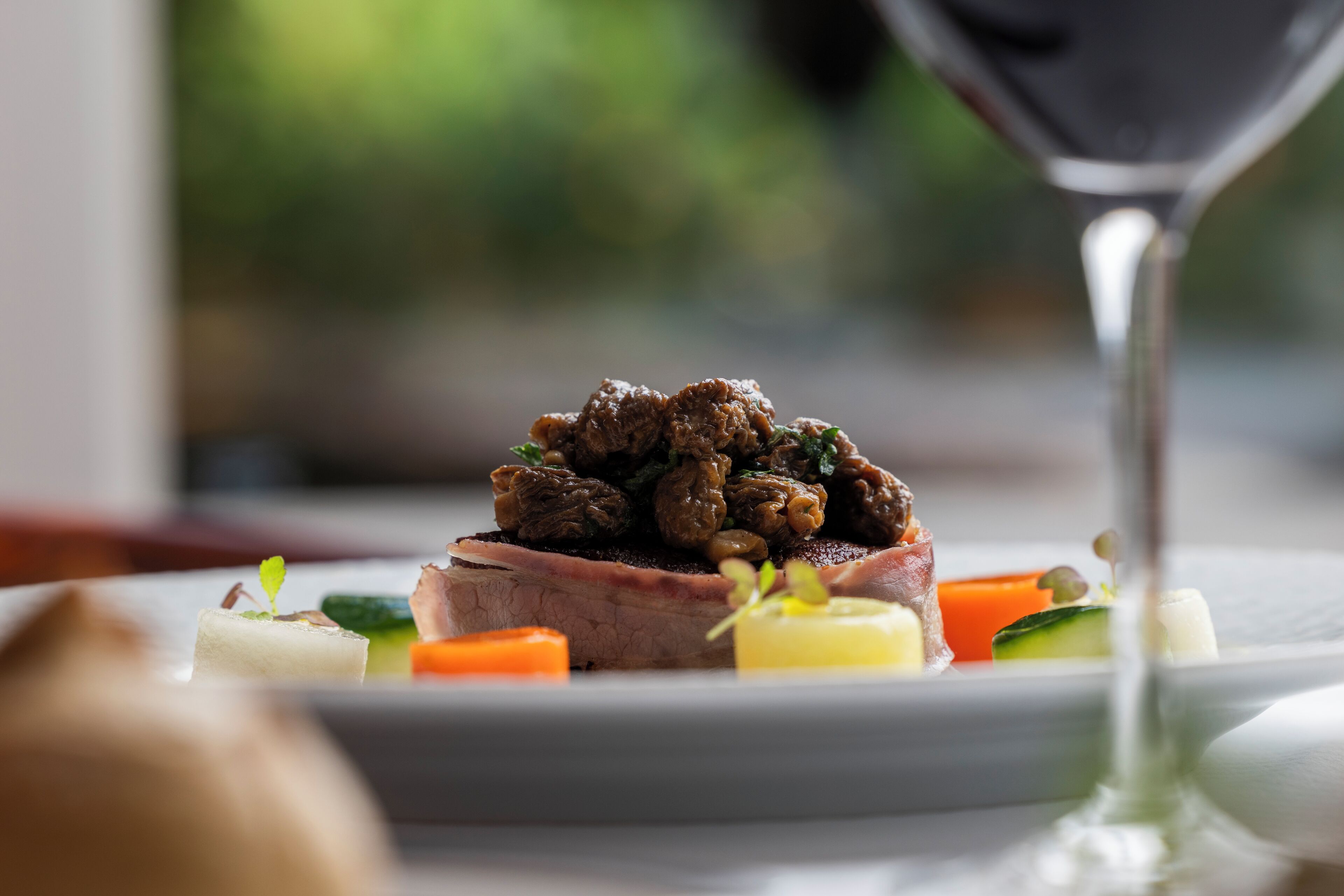 A plate of food with a glass of red wine.