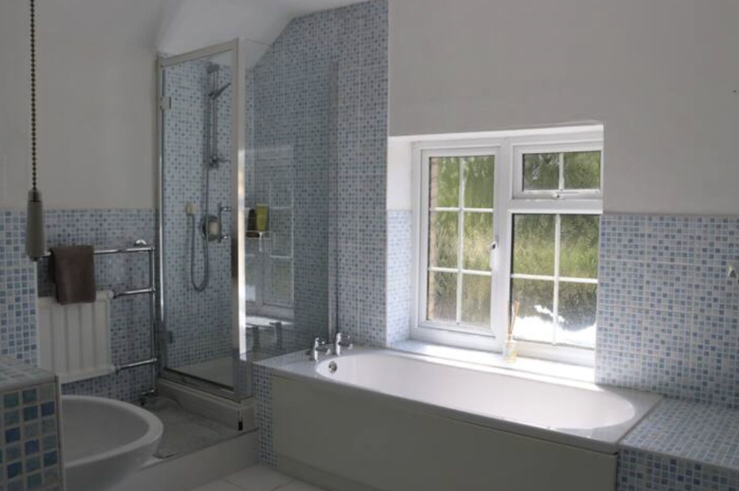 Un bagno con vasca, doccia e finestra.