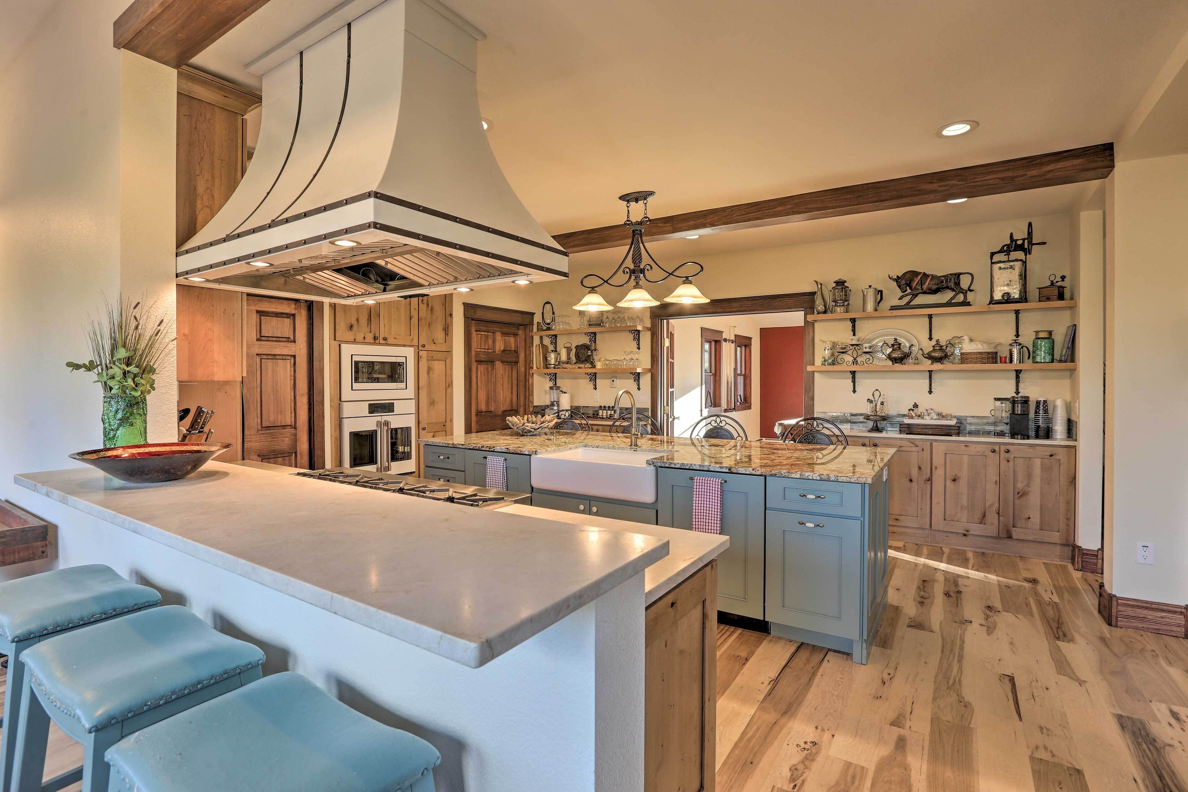 Una cocina moderna con una isla grande, armarios de madera y una campana extractora central.